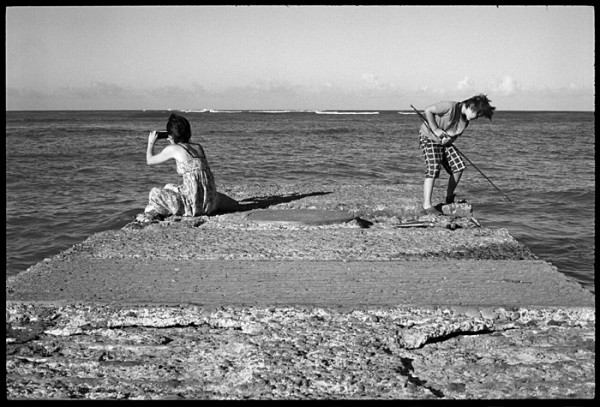 They seemed to be in two separate worlds. She, absorbed in photography. He, looking for fish to spear.