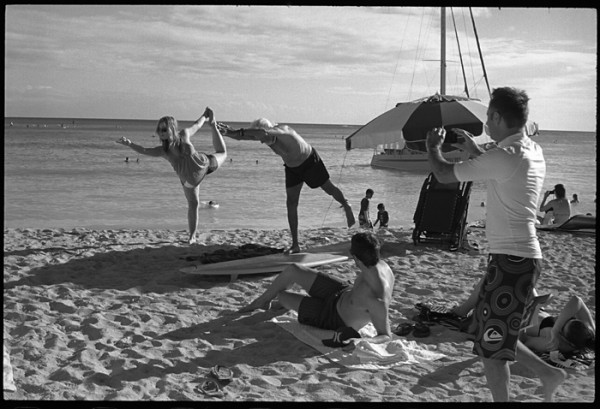 Impromptu yoga session. The older man was doing yoga on his surfboard. The woman was passing by and joined in. 